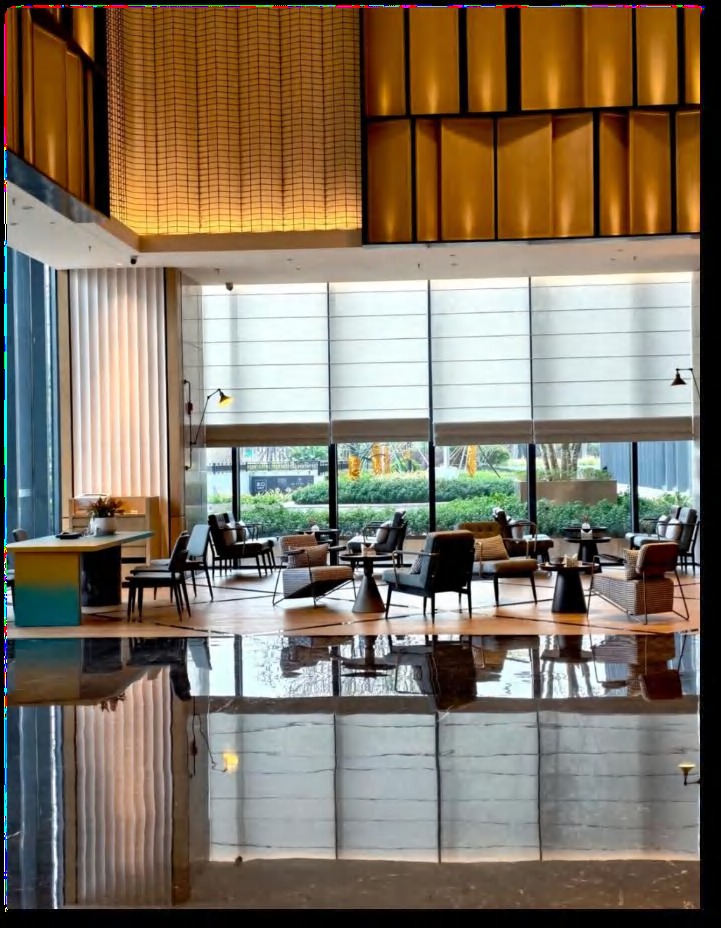 Four Points by Sheraton — grand atrium lobby with golden slat feature wall